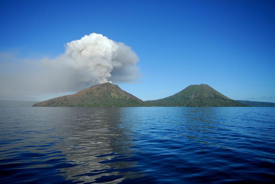 A volcano releasing an ash plume over the sea in Papua New Guinea
